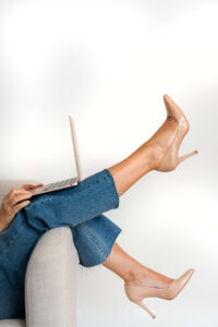 Karen in heels, working on her computer, lying down because she's exhausted