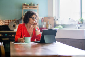 A woman looking at her computer screen researching menopause symptoms